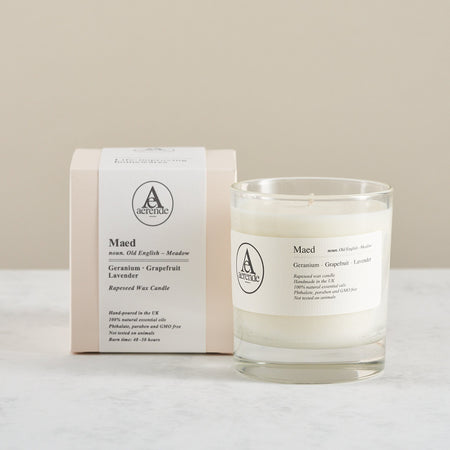 Textured box with bellyband and a rapeseed wax candle in a clear glass